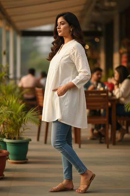 Naanu off-white cotton A-line kurti with chikankari embroidery and cutwork sleeves, worn by a woman with jeans.