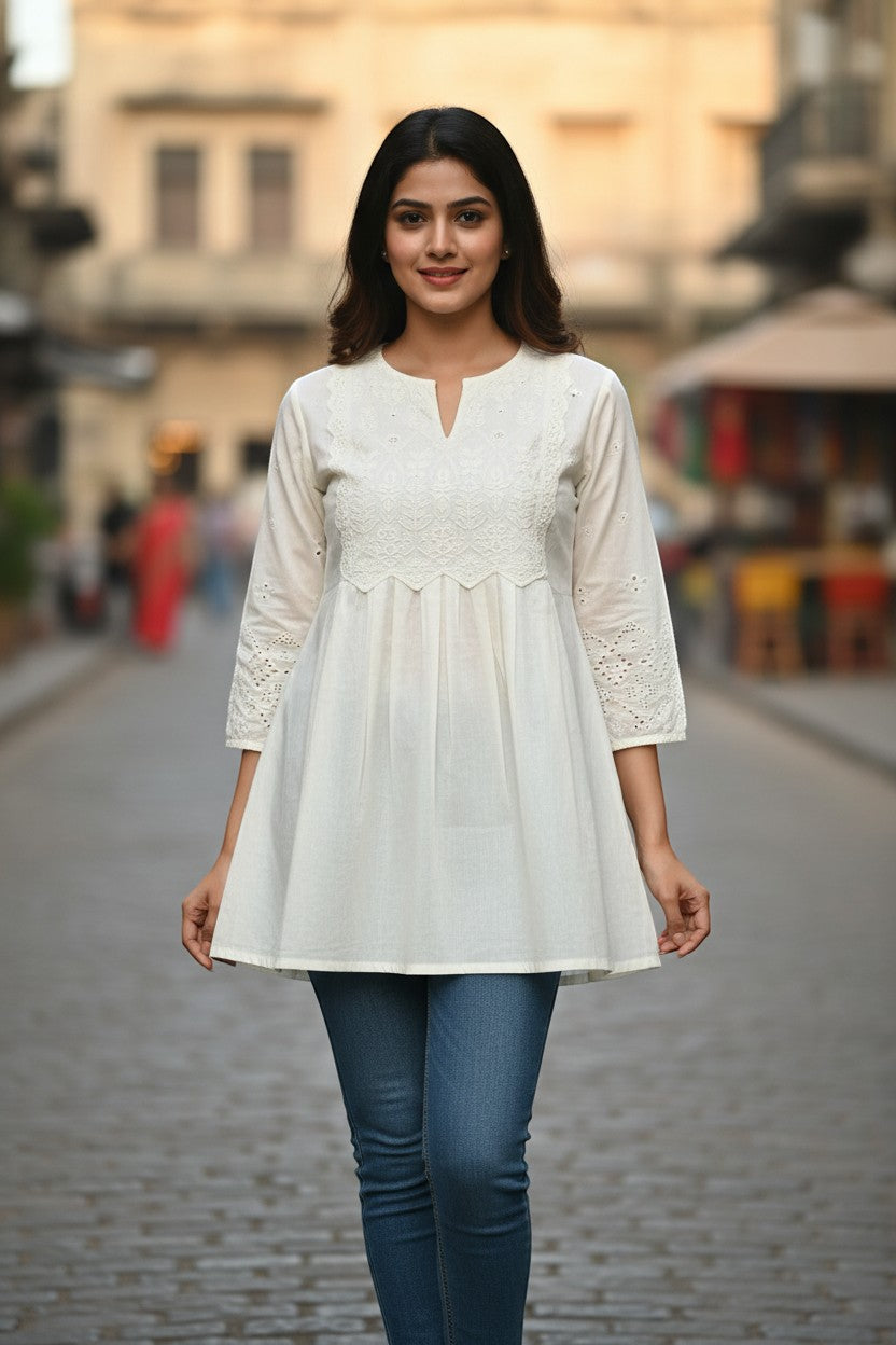Naanu off-white cotton A-line short kurti with white chikankari embroidery on yoke and cutwork sleeves.