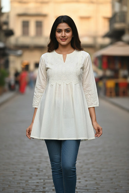 Naanu off-white cotton A-line short kurti with white chikankari embroidery on yoke and cutwork sleeves.