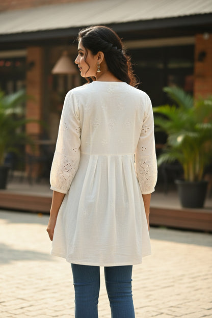 Naanu off-white cotton A-line kurti with white chikankari embroidery on yoke and cutwork sleeves.