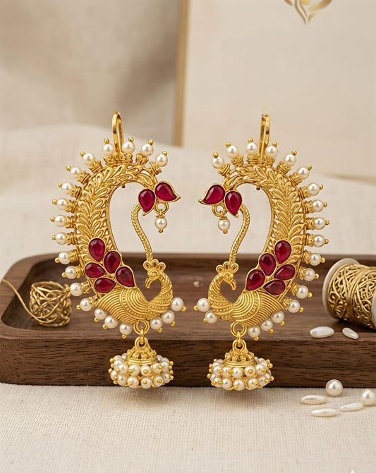 Naanu gold peacock chand bali earrings with ruby kemp stones and pearl jhumka drops. Traditional Indian temple jewellery.