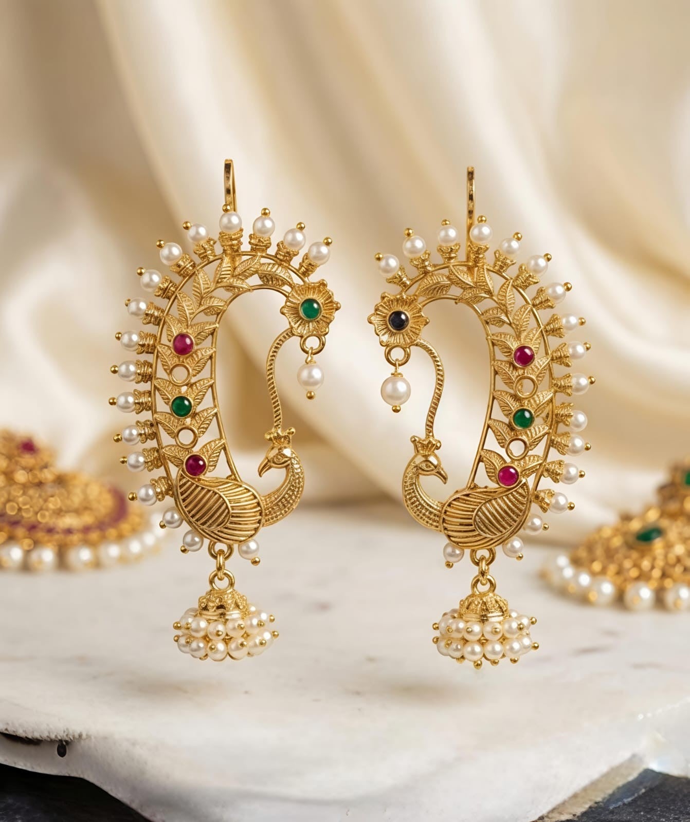 Naanu gold peacock chand bali temple earrings with ruby, emerald, pearl jhumka drops and intricate filigree.