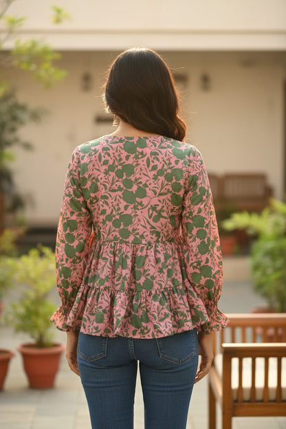 Naanu blush pink satin peplum top with green botanical print, tiered ruffle hem, and full sleeves.