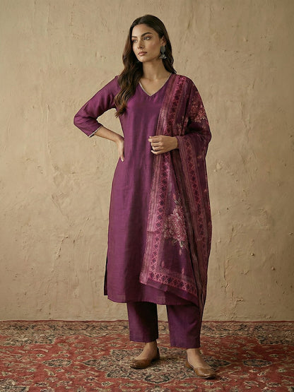 Naanu plum silk blend straight kurta set with V-neck, lace trim, and floral organza dupatta. Model wears silver earrings.