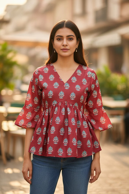 Naanu dark red cotton peplum top with V-neck, bell sleeves, and scattered floral block print in teal and white.