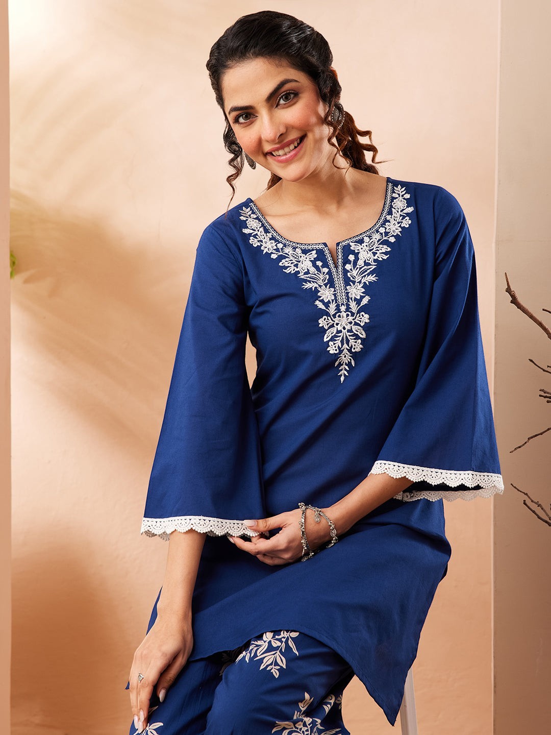 Naanu royal blue cotton co-ord set with white embroidered yoke and botanical print pants. Features bell sleeves with lace trim.