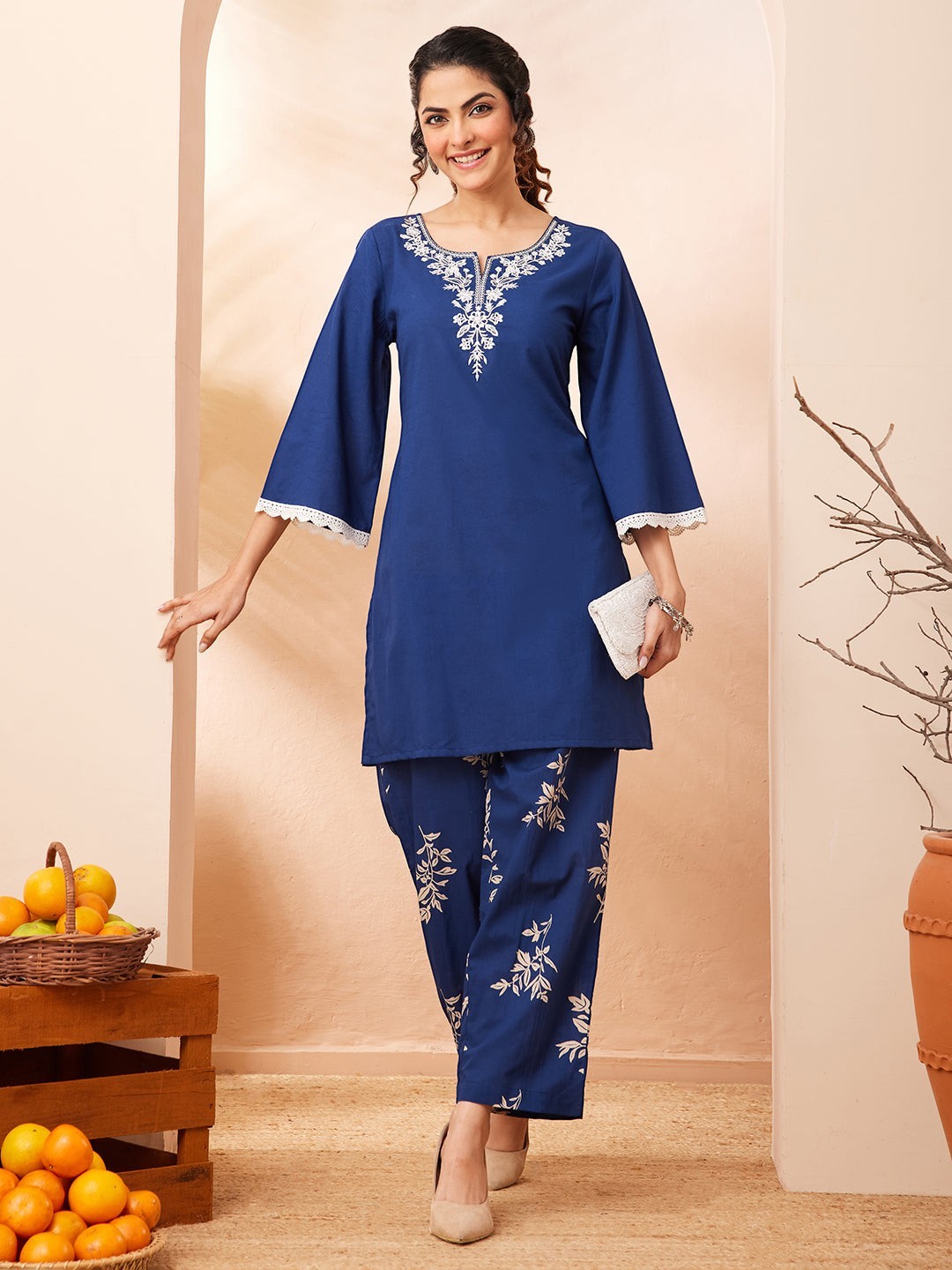 Naanu royal blue cotton co-ord set with embroidered yoke and botanical print straight pants. Features bell sleeves with lace trim.
