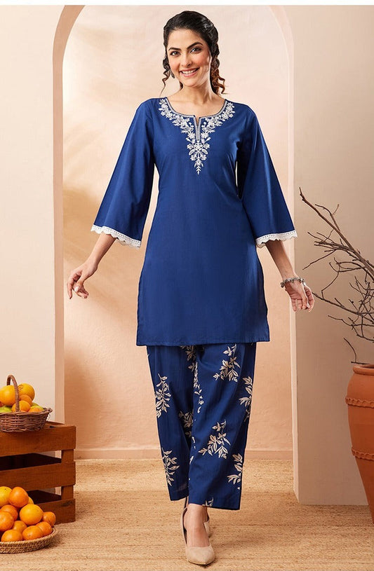 Naanu royal blue cotton co-ord set with white embroidered yoke and botanical print straight pants. Features bell sleeves with lace trim.