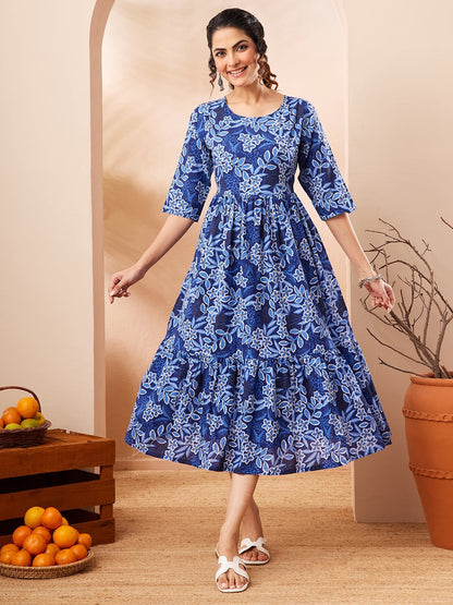 Naanu royal blue floral print midi dress with tiered skirt and 3/4 sleeves, worn by a woman.