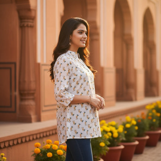 Naanu white short kurti with multicolor butterfly and floral print, mandarin collar, 3/4 sleeves, and button front.