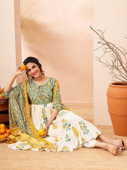 Naanu white and green floral block print Anarkali kurta set with yellow dupatta and tiered ruffle hem. Model wears 3/4 sleeves and round neck.