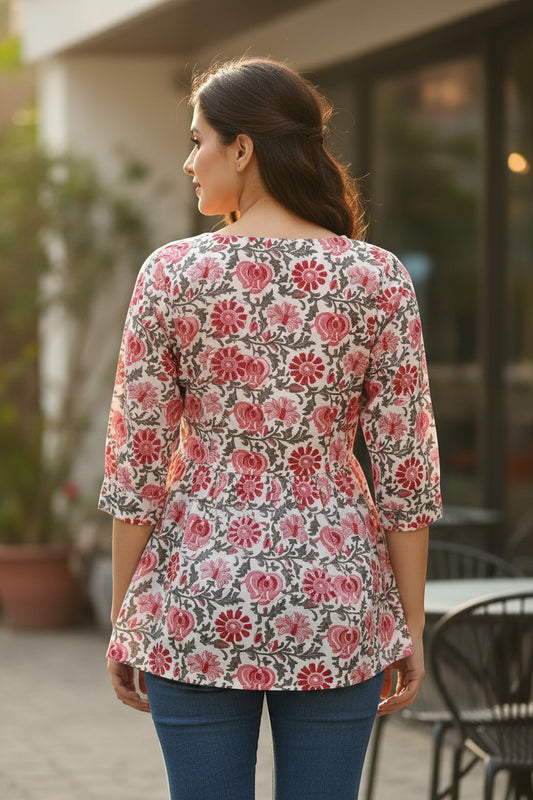 Naanu white cotton kurti with pink and red dahlia floral print, 3/4 sleeves, scoop neck, and A-line silhouette.