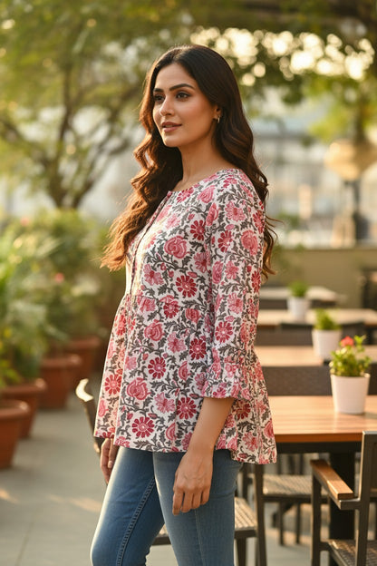 Naanu white cotton kurti with pink and red dahlia floral print, 3/4 sleeves, scoop neck, and A-line flare.