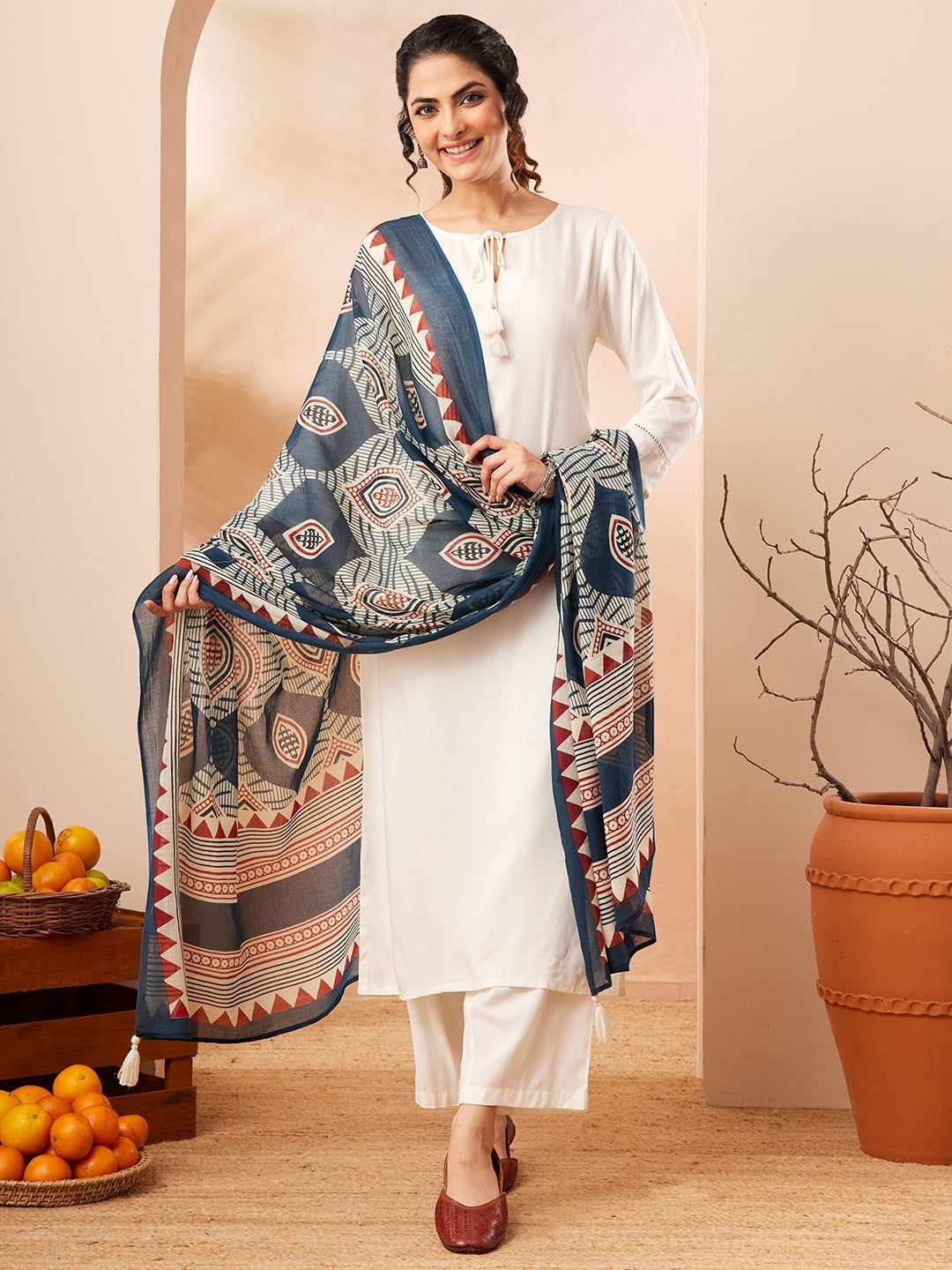 Naanu white rayon kurta set with 3/4 sleeves and tie-up detail, paired with wide-leg palazzo pants and a navy Ajrakh-print dupatta.