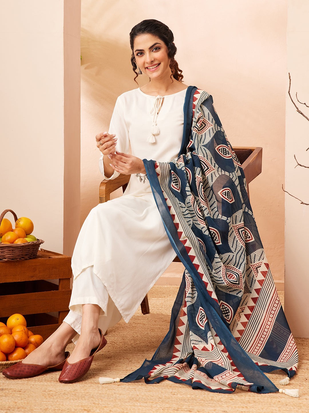 Naanu white rayon kurta set with wide-leg palazzo pants and a navy Ajrakh print dupatta with tassel ends.