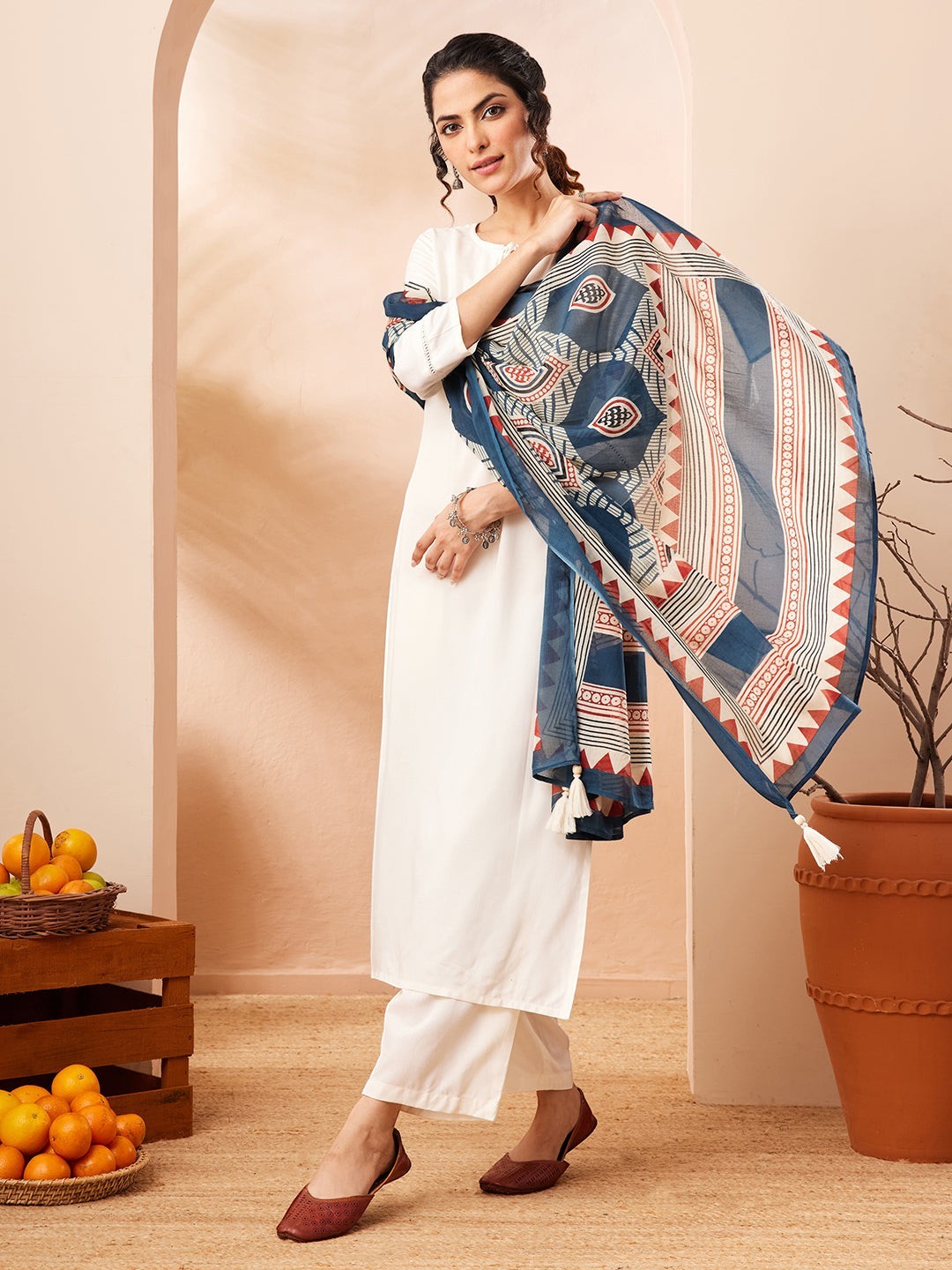 Naanu white rayon straight kurta set with 3/4 sleeves and lace hem, paired with wide-leg palazzo pants and a navy Ajrakh-print dupatta.