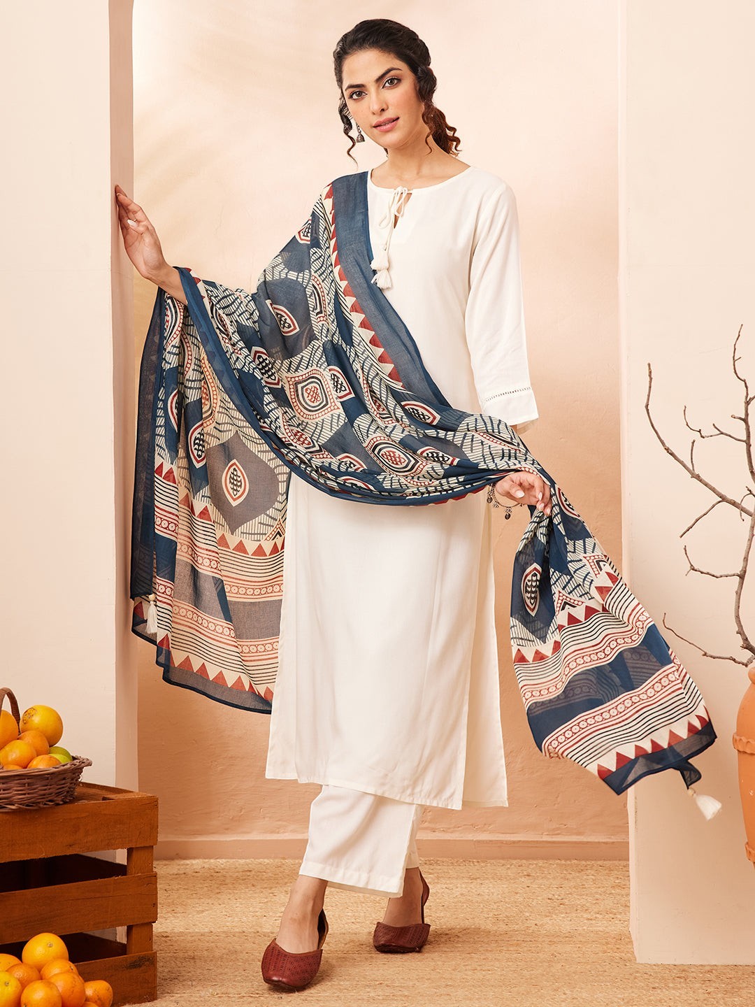 Naanu white rayon kurta set with wide-leg palazzo pants and a navy Ajrakh print dupatta with tassel ends.