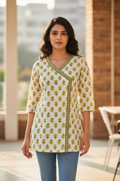 Naanu white cotton kurti with yellow marigold print, V-neck, 3/4 sleeves, and angrakha wrap detail.