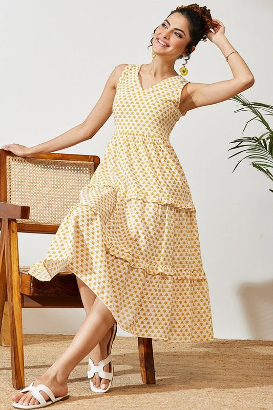Naanu yellow butti print cotton midi dress with V-neck, empire waist, and double ruffle tiered hem. Sleeveless with pockets.