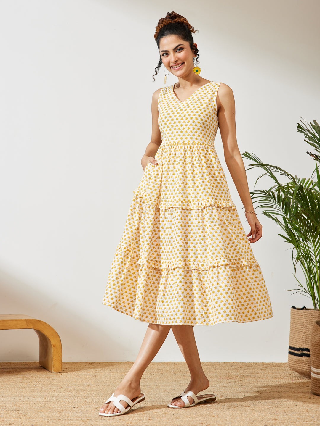 Naanu yellow butti print cotton midi dress with V-neck, empire waist, tiered hem, and pockets.