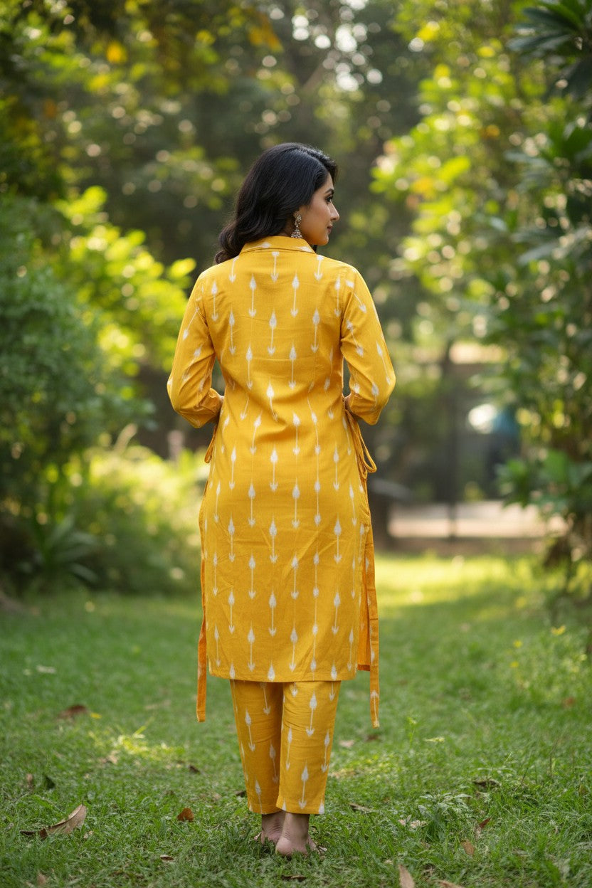 Naanu yellow ikat arrow print straight kurta with 3/4 sleeves and matching pants. Features a shirt collar and side tie-up detail.