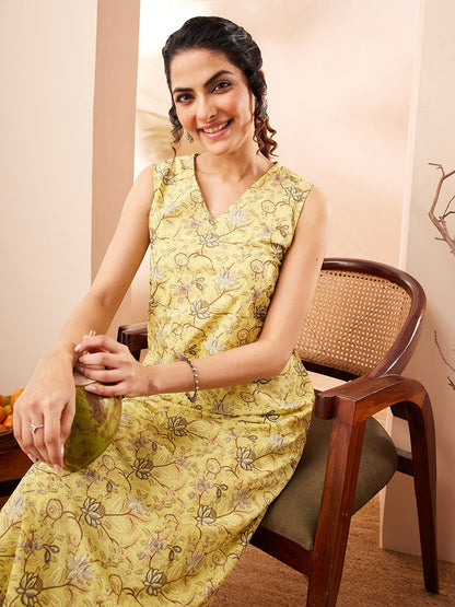 Naanu yellow sleeveless V-neck kurta with lotus print and matching palazzo pants, worn by a woman sitting on a chair.