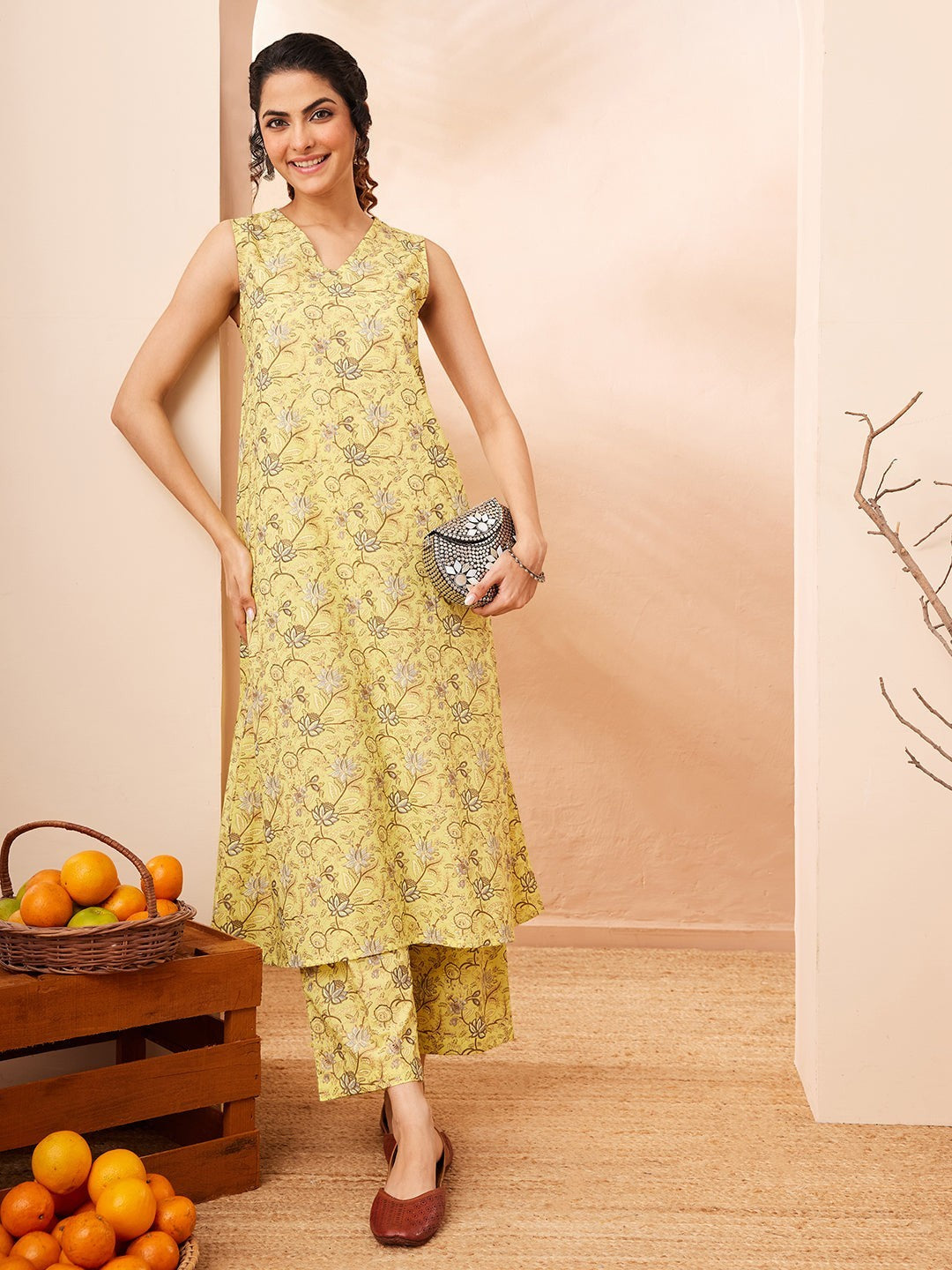 Naanu yellow sleeveless V-neck kurta with lotus print and matching palazzo pants, worn by a model.