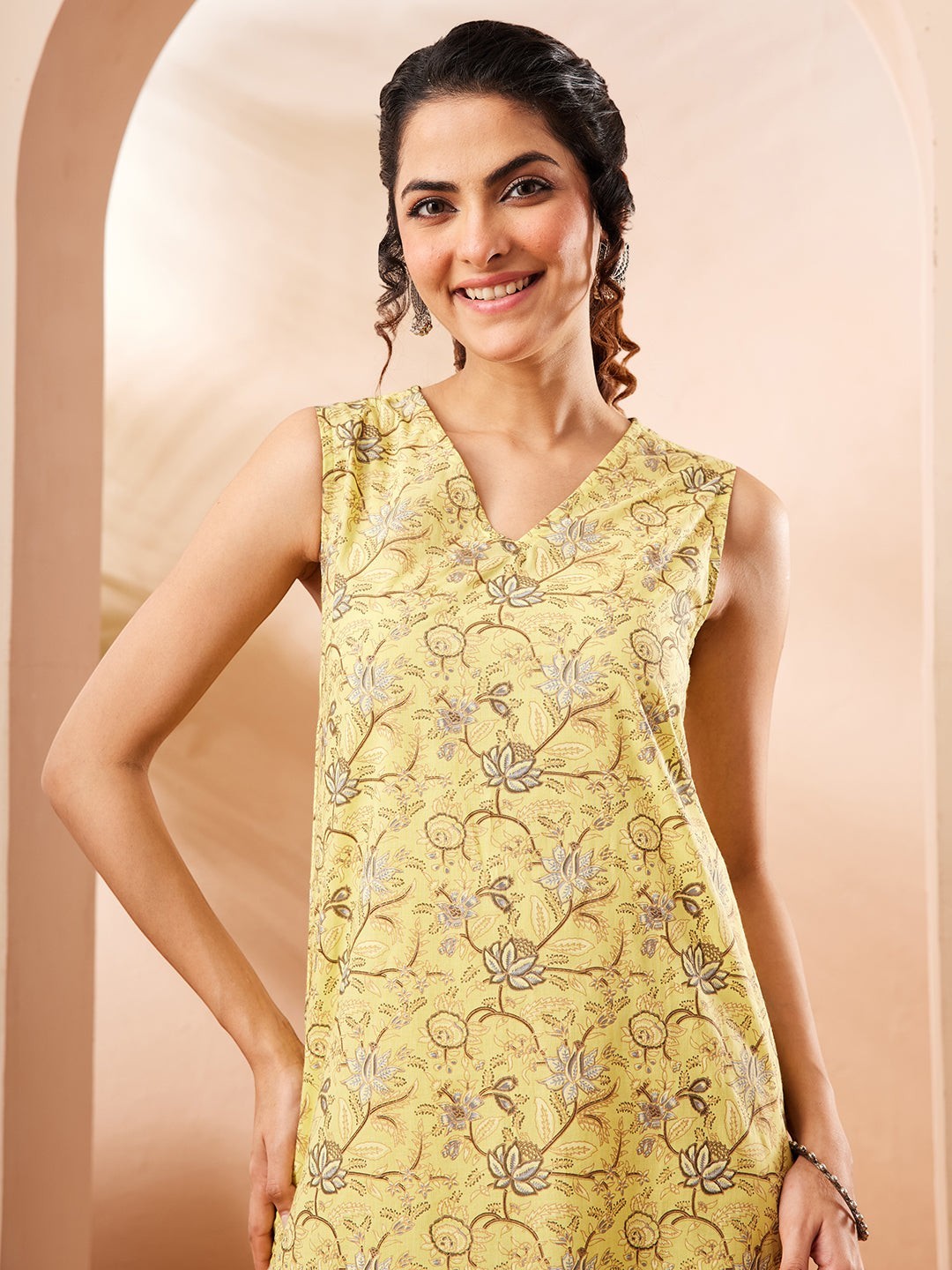 Naanu yellow sleeveless V-neck kurta with lotus and floral print, paired with matching palazzo pants.